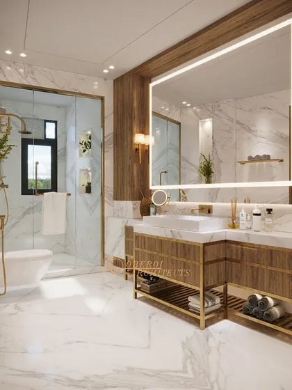 This bathroom combines white marble walls, wood-paneled accents, and gold fixtures to create a bright and luxurious space.