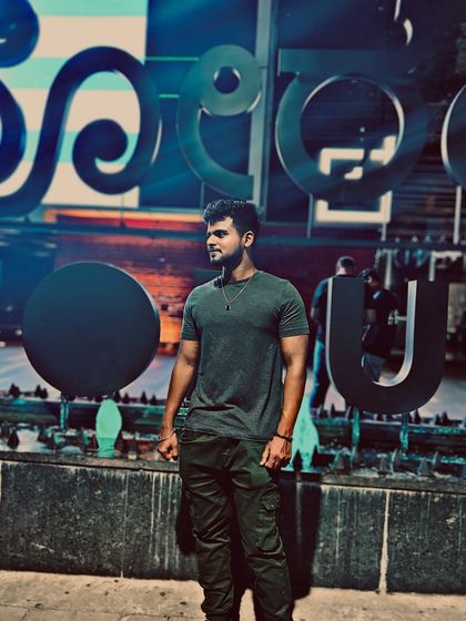 Posing in front of a large public art installation in Bengaluru at night.
