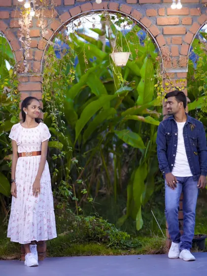 A candid-style shot of the couple in a garden archway, capturing a natural and unposed moment.
