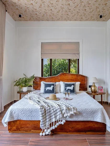Another cozy bedroom in the mountain home, with a beautiful wooden bed and large windows that offer a refreshing view of the outdoors.