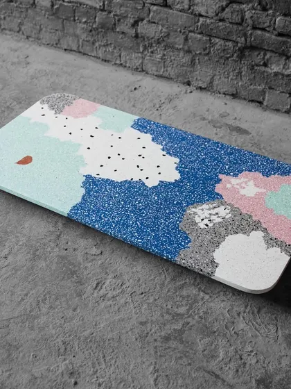 This multi-color terrazzo tabletop was custom-made for a client. The abstract, flowing shapes of different colors create a playful and artistic surface, turning a simple table into a centerpiece.