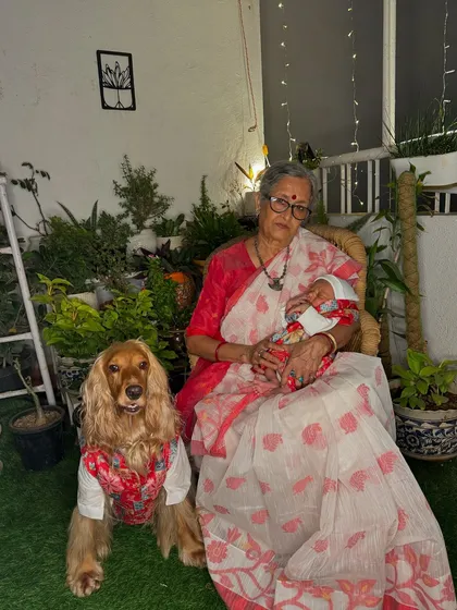 Grandma and her two grandsons, human and furry, sharing a special moment during Diwali.
