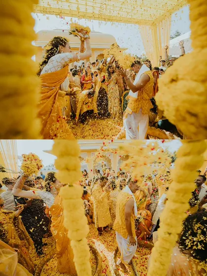 A dynamic shot from within the marigold decor, capturing the couple being showered with an explosion of yellow petals.