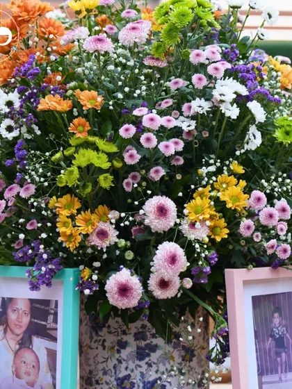 A vibrant floral arrangement beautifully frames childhood photos of the couple, celebrating their journey to parenthood.