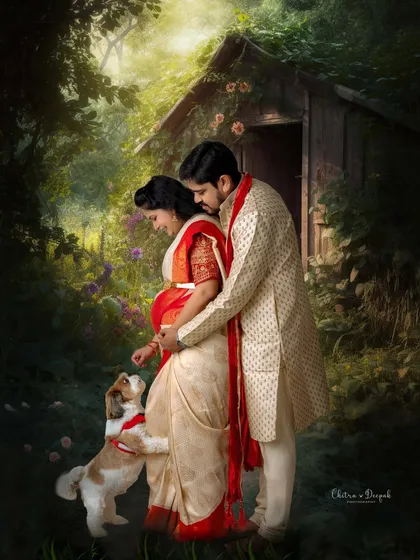 An artistic and romantic maternity portrait of a couple in traditional Indian attire, sharing a tender moment with their beloved pet in a magical, painterly forest setting. This highlights our ability to create fine art pieces and include furry family members.