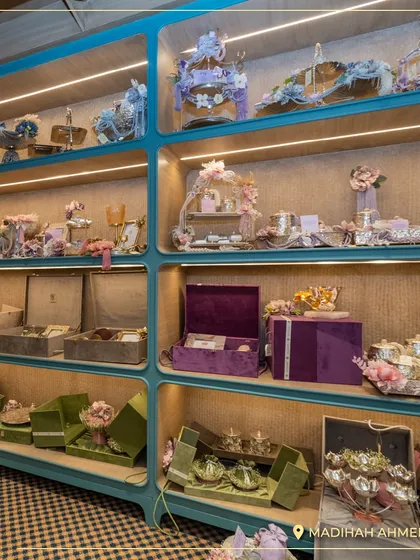The display shelves at our Ahmedabad store, showcasing a wide array of our gift hampers and decorative items. The color-coded sections help clients easily navigate our collections.