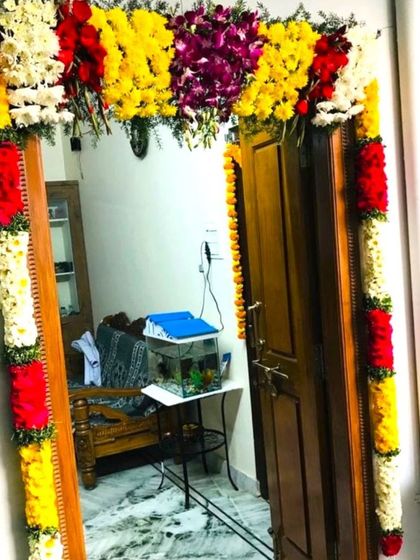 Flower decorations for an apartment door for a housewarming. The colorful garlands of fresh flowers create a festive and welcoming entrance.