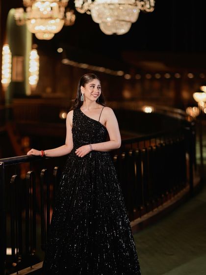 Full-length shot showing off the shimmery black gown and the glamorous makeup for a perfect party look.