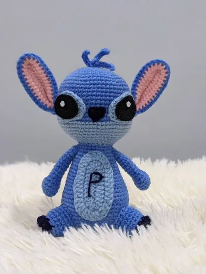 A custom-made Stitch amigurumi, complete with his big ears and mischievous look. This one has the initial 'P' embroidered on his belly for a personal touch.