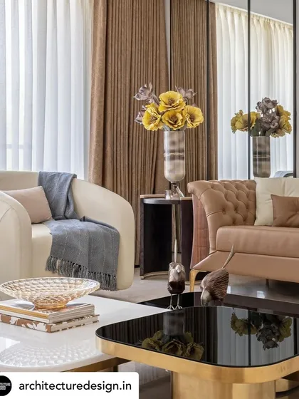 Curated decor and plush furnishings in tones of cream and brown add warmth and texture to the living room. Large windows dressed in dual-layered curtains allow for controlled natural light, enhancing the room's ambient quality.