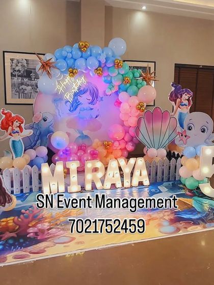 An under-the-sea adventure with The Little Mermaid theme. This beautiful setup for Miraya's 5th birthday features an ocean-themed floor mat, character cutouts, and a bubble-like balloon garland.