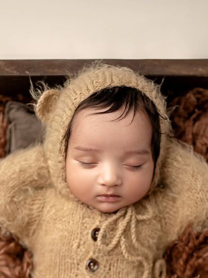 A top-down view of our little bear cub. This angle shows off the cute details of the teddy bear outfit and the baby's peaceful pose.