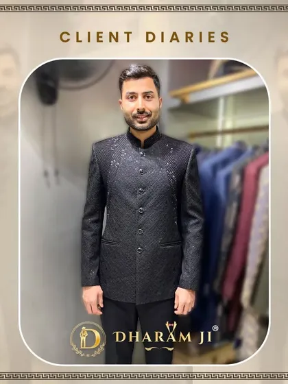 A happy client in a black, subtly embroidered bandhgala jacket. He looks comfortable and confident in his new bespoke piece.