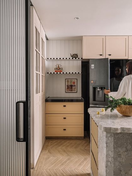 The spacious kitchen at Kanso House, showing the island and ample storage. The design balances low-maintenance materials with elegant finishes.