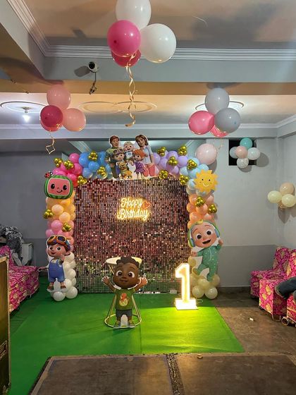 A wider shot of the Cocomelon party hall, showing the main backdrop and ceiling balloons.
