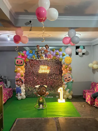 A wider shot of the Cocomelon party hall, showing the main backdrop and ceiling balloons.