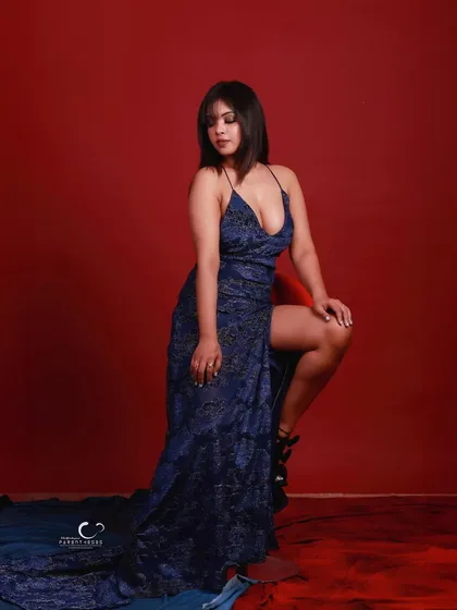 A powerful kneeling pose that showcases the thigh-high slit and the intricate pattern of the dress.