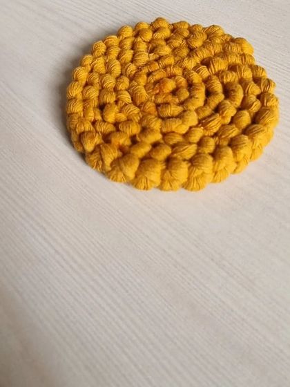 A simple, elegant coiled coaster in a beautiful mustard yellow, made without fringes for a cleaner look.