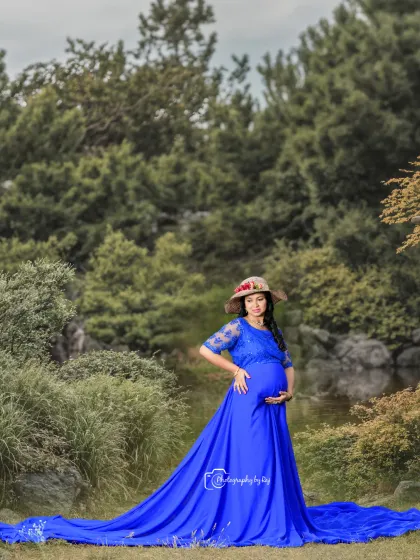 A beautiful solo portrait in a royal blue gown. The long, flowing train of the dress looks stunning against the natural landscape.
