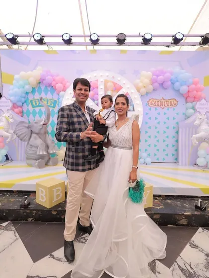 The happy family celebrating a first birthday in front of the pastel carnival backdrop I designed. It's always a joy to see my creations become the setting for such precious memories.