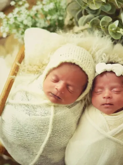 Two little angels sleeping side-by-side. Dressed in neutral cream colors, this portrait highlights the peacefulness and innocence of newborn twins.