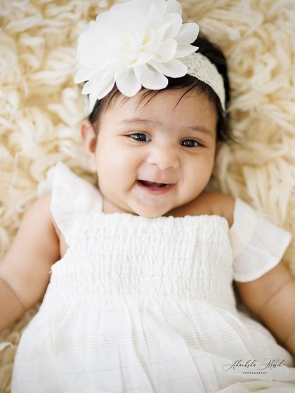 A happy and alert baby girl, smiling for the camera. I love capturing these moments of connection, where their little personality starts to shine through.