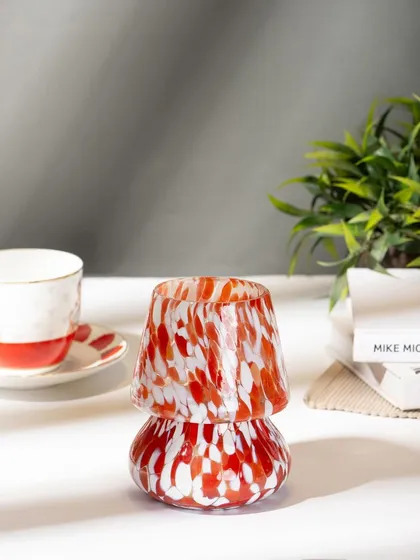 A lifestyle shot of a mushroom-shaped candle holder from Lighthouse, placed on a desk. This shows the product in a realistic home or office setting.