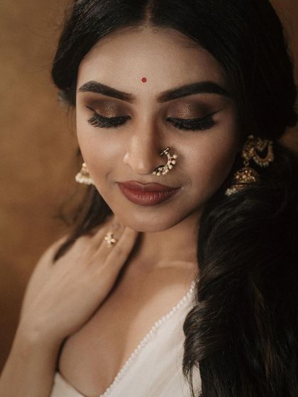 A classic look featuring a dramatic smokey eye and a traditional nose ring. This demonstrates how to balance bold eye makeup with a softer lip for a captivating effect.