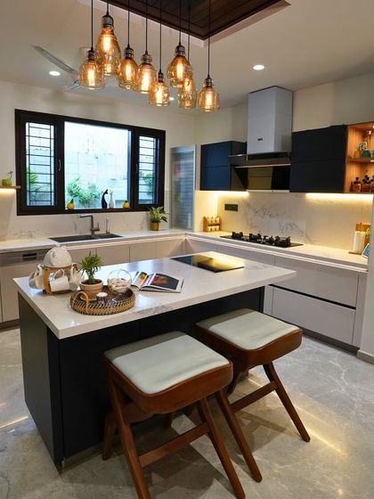This view shows the two cooking zones: a modern induction hob on the island for Fariha and a traditional gas stove on the main counter for her mother-in-law, catering to different cooking styles.