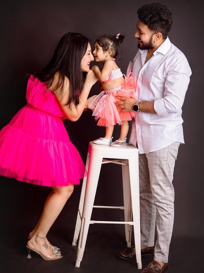 A playful and sweet moment between mother, father, and daughter. Using a stool as a prop adds dimension and creates opportunities for cute interactions.