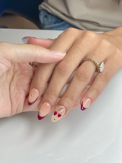 A chic and trendy set featuring a deep red French tip and cute cherry nail art. This student work shows their ability to create playful yet elegant designs.