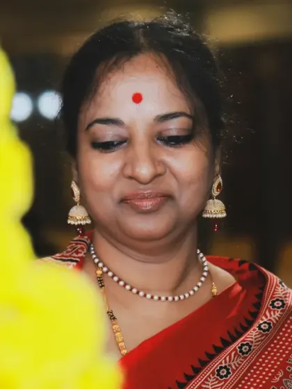 A warm, candid portrait of a guest at a family event. Her gentle smile is captured with soft, natural-looking light, showing that even those not in the spotlight can have their beautiful moments preserved.