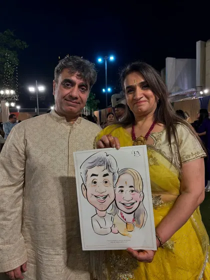 A couple holding their caricature at an outdoor evening event. Live art adds a unique and engaging element to any party or wedding function.