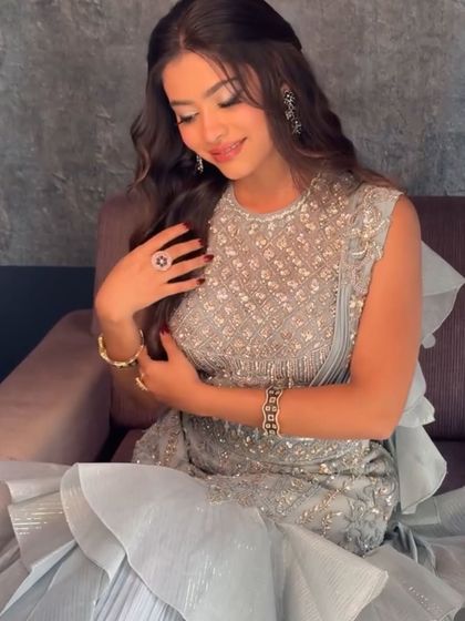 A client looking lovely in our powder blue indo-western outfit. The ruffled saree-style drape is a modern and chic detail.