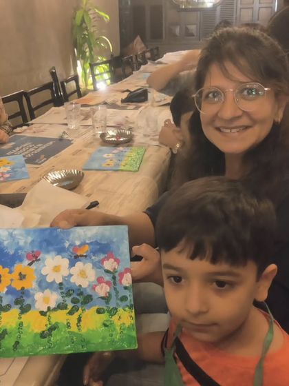 A mother and son team up to show their completed floral painting, a lovely memory from the party.