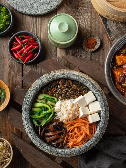 A vegetarian stone bowl from YouMee, with neatly arranged tofu, carrots, and bok choy.