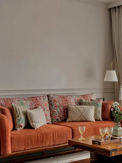 A close-up on the terracotta sofa, highlighting the mix of traditional and geometric patterns on the cushions. This layering of textiles adds depth and personality to the room.