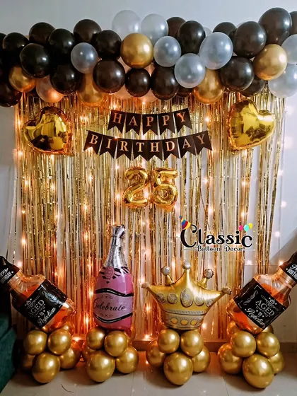 We can create fun, themed decorations for a 25th birthday house party. This setup includes a gold shimmer curtain, a 'Happy Birthday' banner, and fun props like foil champagne and whiskey bottle balloons.