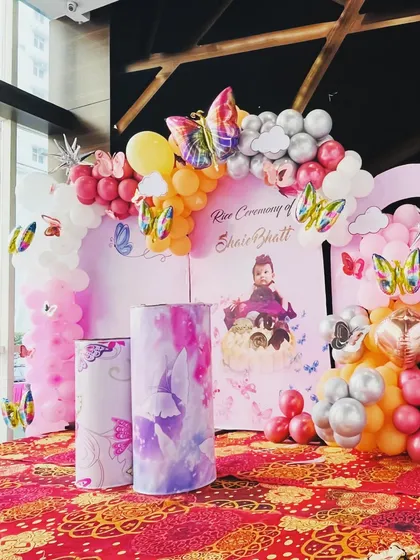 A side view of the rice ceremony decoration, highlighting the mix of balloon colors and the shiny butterfly foil balloons.