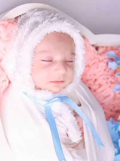 A tight close-up on the baby's face, showing the delicate features and the softness of the bunny bonnet.