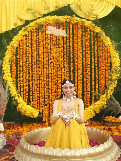 This is what a dream Haldi ceremony looks like. I created this stunning backdrop using hundreds of fresh genda phool (marigolds) to create a circle of sunshine for the beautiful bride.