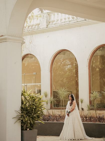 A portrait using the venue's architecture to frame the bride. The repeating arches create a beautiful backdrop, making her look graceful and serene.