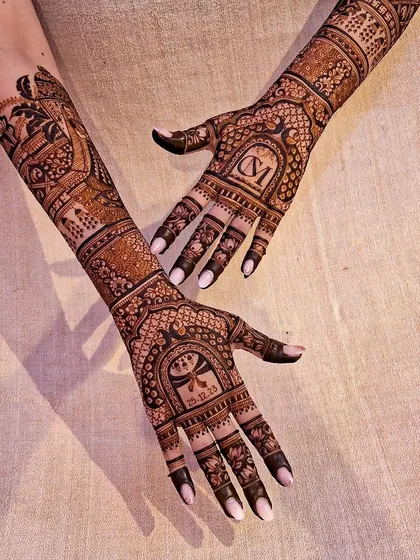 A heavy bridal back-hand design, featuring the couple's initials and wedding date, surrounded by intricate traditional patterns.