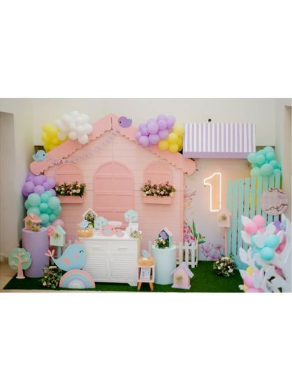 A wide shot of the adorable birdhouse party, showing the full scale of the custom-built house backdrop and props.