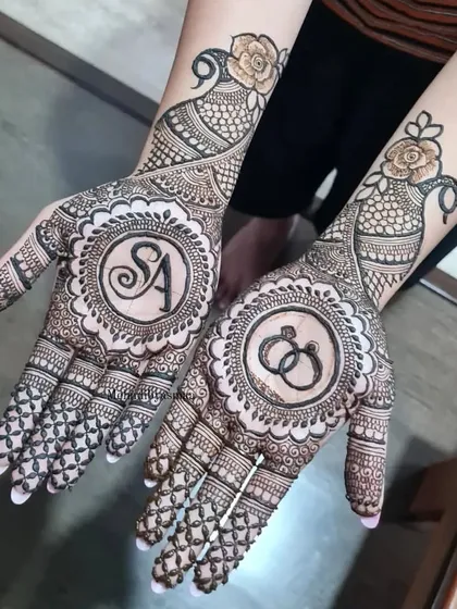 A perfect engagement design with the couple's initials 'S' and 'A' in one mandala, and interlocking rings in the other.