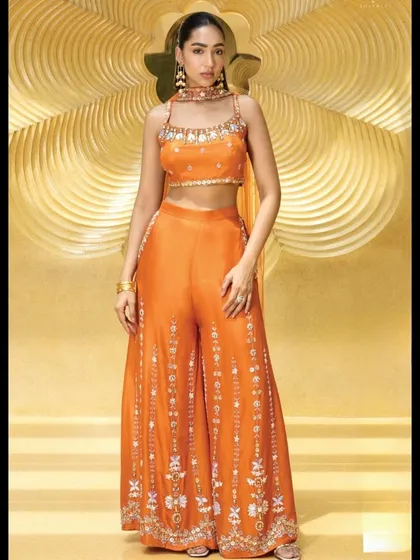 This vibrant orange palazzo set is a modern and chic option for a mehendi or sangeet. The wide-leg pants offer comfort, while the heavily embellished crop top adds a touch of glamour.