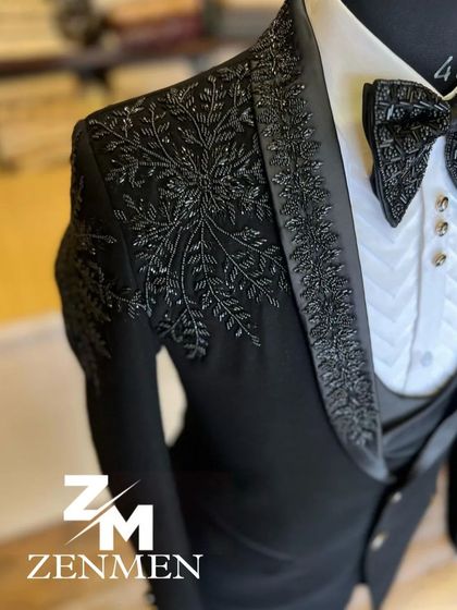 Another angle of the black-on-black embroidered tuxedo, showing the detail from the side. The texture of the embroidery adds depth to the all-black look.