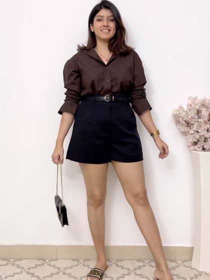 A simple yet sophisticated combination. These black high-waisted shorts are paired with a brown button-down shirt and a sleek black belt, creating a polished and put-together casual look.