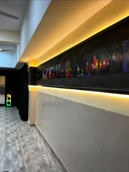 Our studio is decorated to inspire. This wall features a gallery of moments from our past shows, lit with warm ambient lighting to create a welcoming and motivating vibe for all our dancers.