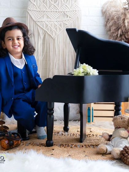 A handsome young man with a charming smile. Dressed in a smart blue suit, he looks ready for his big performance at the piano.